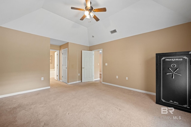 unfurnished bedroom with carpet flooring, baseboards, ensuite bathroom, high vaulted ceiling, and a ceiling fan