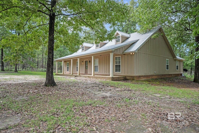 view of front of property with board and batten siding, a porch, and metal roof