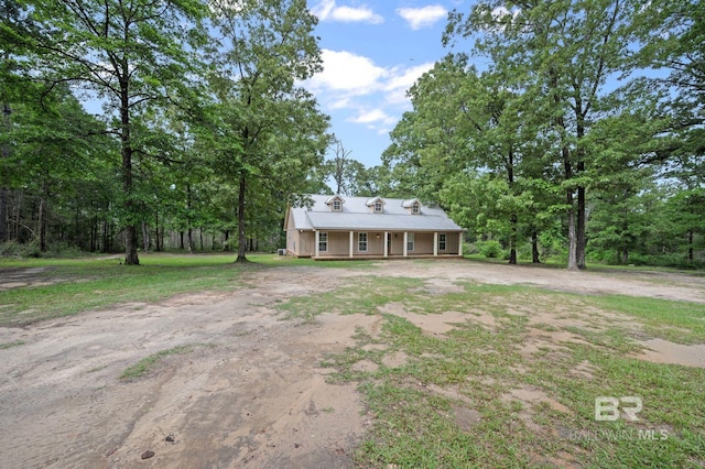 view of front of house with dirt driveway and a porch