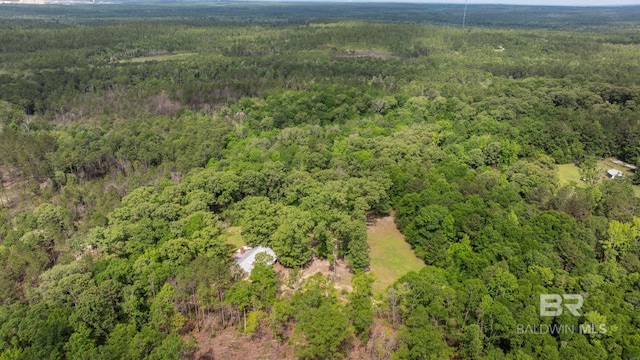 aerial view of property and surrounding area featuring a heavily wooded area