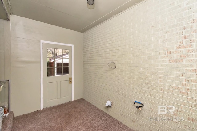 interior space with brick wall and carpet flooring