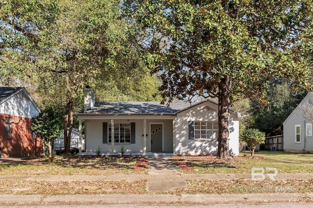 view of front of house with covered porch and a chimney