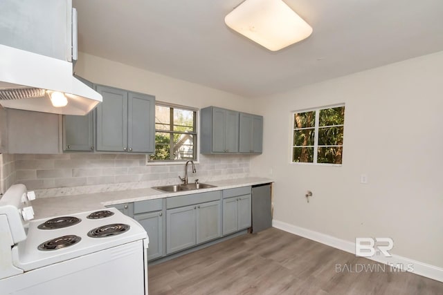 kitchen featuring under cabinet range hood, electric range, a sink, stainless steel dishwasher, and decorative backsplash