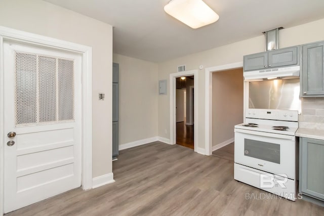 kitchen featuring white range with electric cooktop, gray cabinets, light countertops, light wood-type flooring, and under cabinet range hood