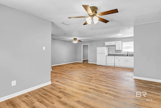 3304 Armond St, Mobile, AL 36605 - unfurnished living room featuring ceiling fan, a textured ceiling, and light wood-style flooring