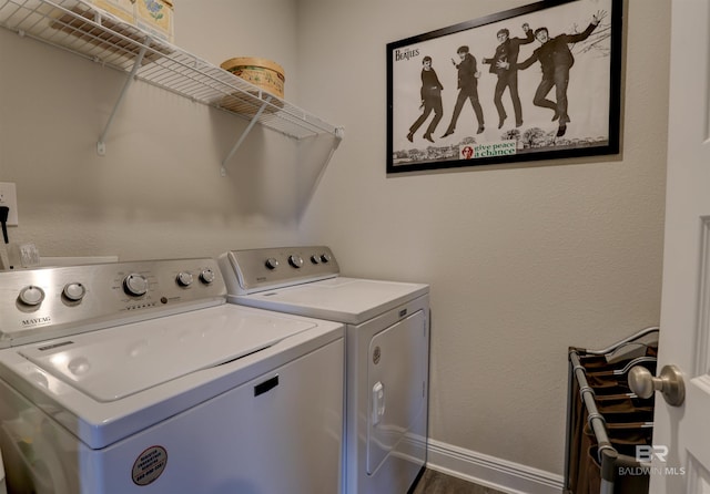 clothes washing area with washing machine and clothes dryer and dark hardwood / wood-style floors