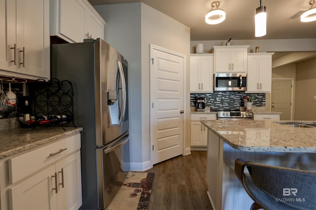 kitchen featuring decorative light fixtures, stainless steel appliances, white cabinetry, and dark hardwood / wood-style floors