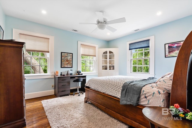 bedroom with dark hardwood / wood-style flooring and ceiling fan