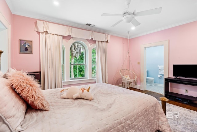 bedroom featuring crown molding, dark wood-type flooring, ceiling fan, and ensuite bath