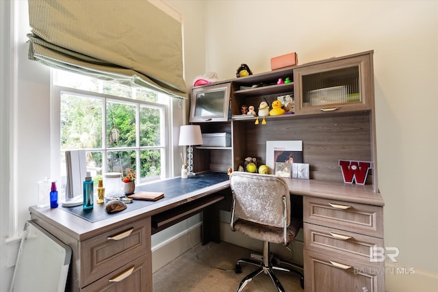 home office with built in desk and concrete floors