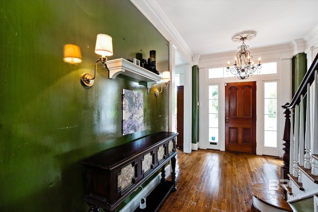 foyer entrance with an inviting chandelier, crown molding, and wood-type flooring