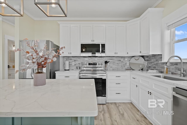 kitchen with light stone countertops, appliances with stainless steel finishes, sink, and white cabinets