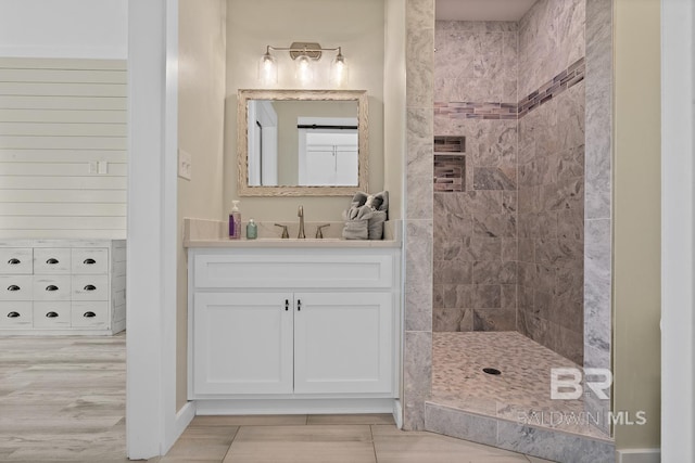 bathroom featuring a tile shower and vanity