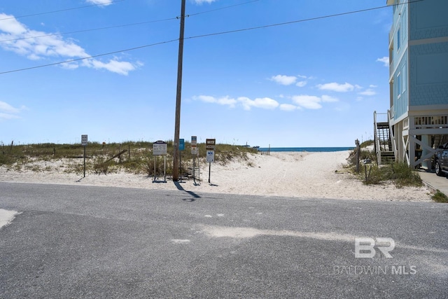 view of street featuring a water view and a beach view