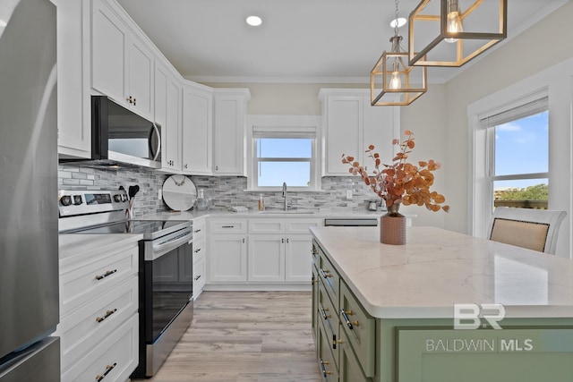 kitchen with stainless steel appliances, white cabinetry, light stone counters, and a kitchen island