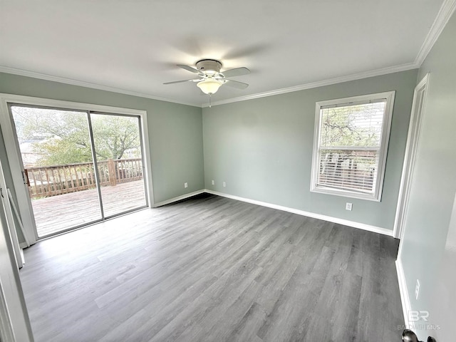 spare room featuring crown molding, baseboards, ceiling fan, and wood finished floors