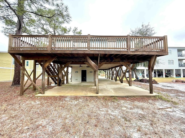 view of property's community featuring a carport, a patio area, a deck, and stairs