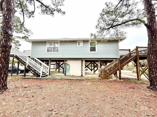 back of property with a carport, stairway, and driveway