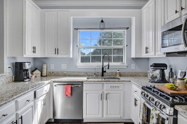 kitchen featuring white cabinetry, ornamental molding, appliances with stainless steel finishes, and a sink