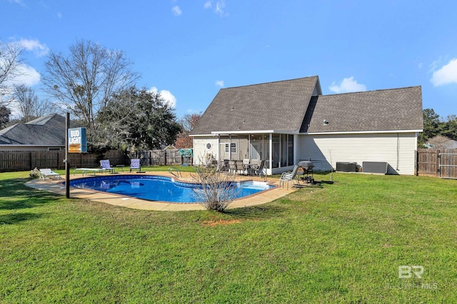 view of pool featuring a lawn, a patio, a fenced backyard, a sunroom, and a fenced in pool