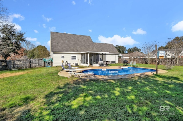 back of property featuring a fenced in pool, a lawn, a fenced backyard, and a sunroom