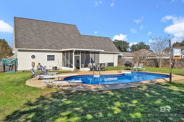 rear view of property with a patio, a lawn, and a sunroom