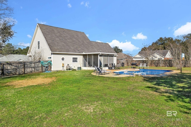 rear view of house featuring a patio, a fenced backyard, a yard, a sunroom, and a fenced in pool