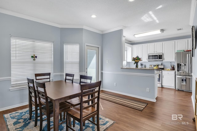 dining area with baseboards, dark wood-style floors, visible vents, and ornamental molding