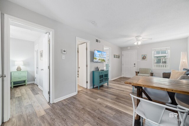 dining space with ceiling fan and light hardwood / wood-style floors