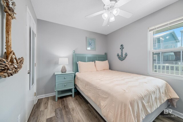 bedroom featuring dark hardwood / wood-style floors, ceiling fan, and a closet