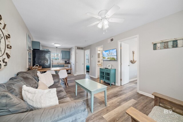 living room featuring light hardwood / wood-style floors and ceiling fan