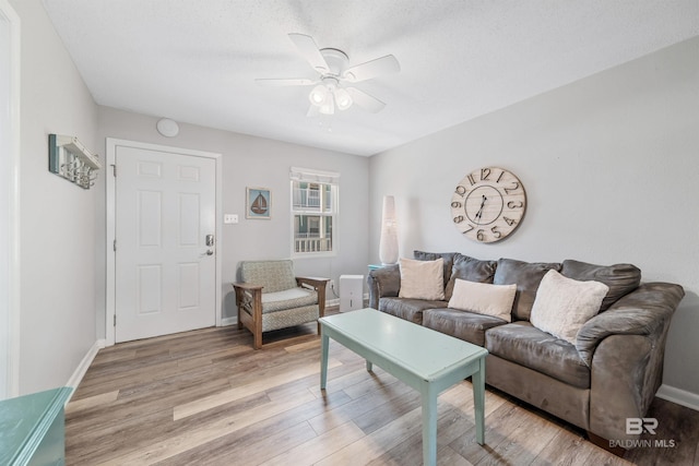 living room with ceiling fan and light hardwood / wood-style flooring