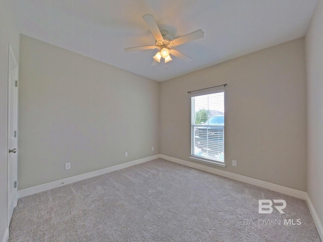 spare room with ceiling fan and light colored carpet