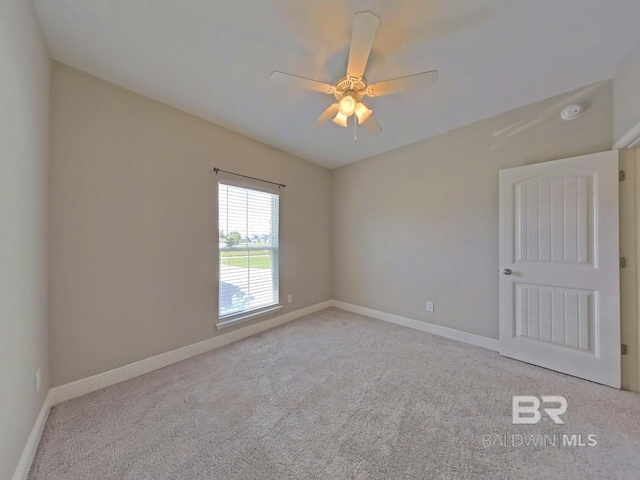 spare room with ceiling fan and light colored carpet