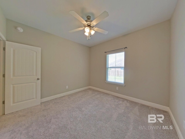 spare room featuring light carpet and ceiling fan