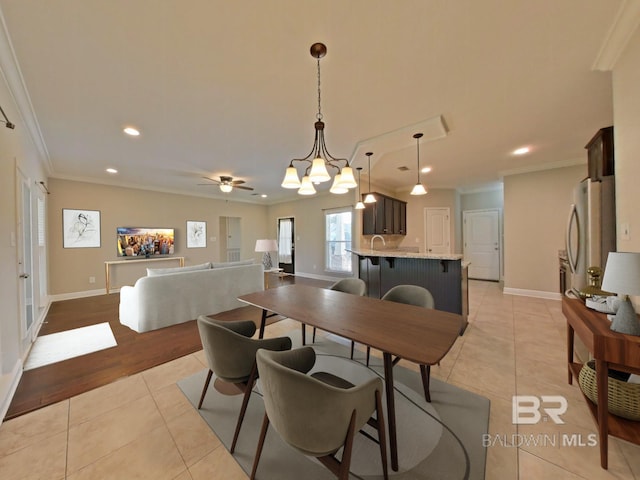 dining space featuring crown molding, ceiling fan, and light tile patterned floors