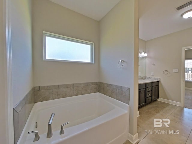 bathroom with tile patterned flooring, vanity, and a bathing tub