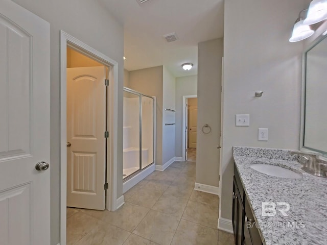 bathroom with tile patterned floors, vanity, and a shower with shower door