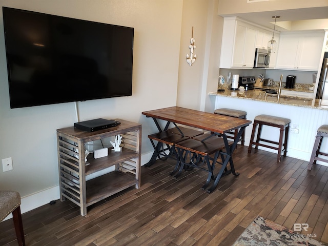 dining area featuring dark wood-style floors and baseboards
