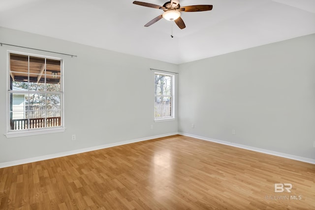 unfurnished room with lofted ceiling, a ceiling fan, baseboards, and light wood finished floors