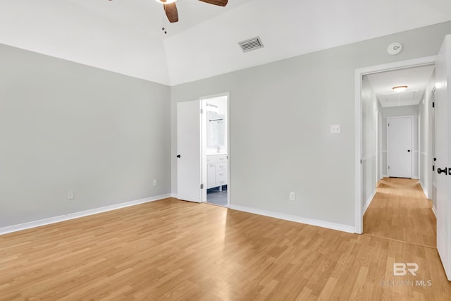 unfurnished bedroom with light wood finished floors, visible vents, baseboards, attic access, and ensuite bathroom