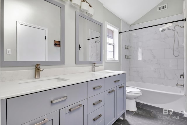 bathroom with double vanity, toilet, lofted ceiling, and a sink