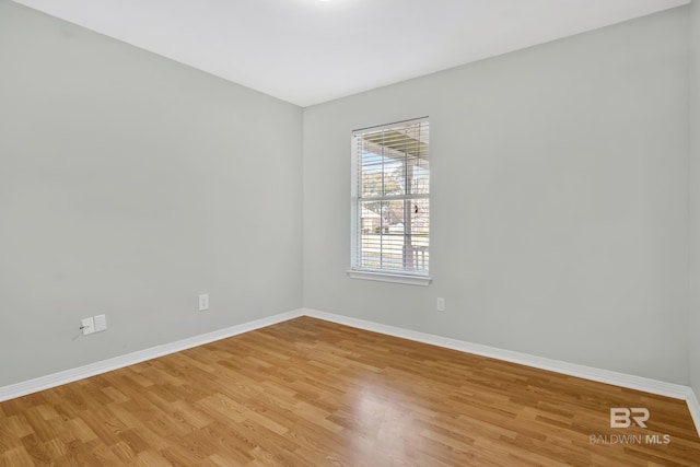 empty room with light wood-style flooring and baseboards