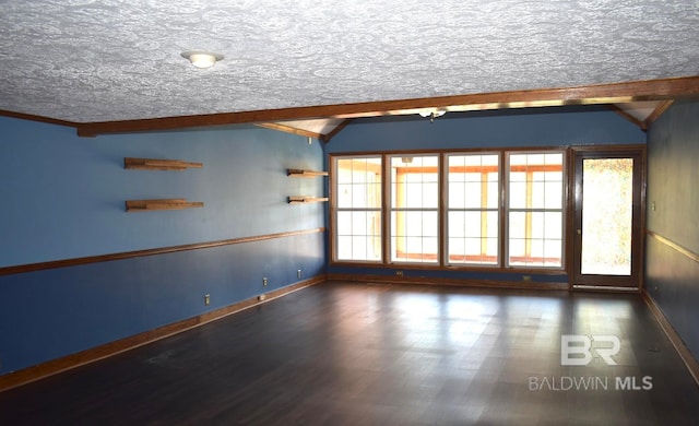 empty room with dark hardwood / wood-style floors, lofted ceiling with beams, and a textured ceiling