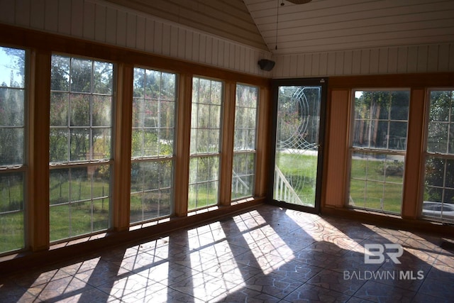 unfurnished sunroom featuring a wealth of natural light and vaulted ceiling