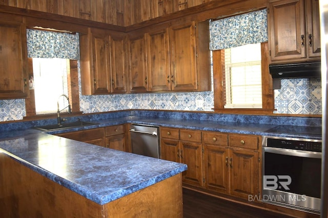 kitchen featuring backsplash, sink, stainless steel appliances, and a healthy amount of sunlight