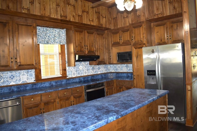 kitchen featuring wood walls, tasteful backsplash, stainless steel appliances, and ceiling fan