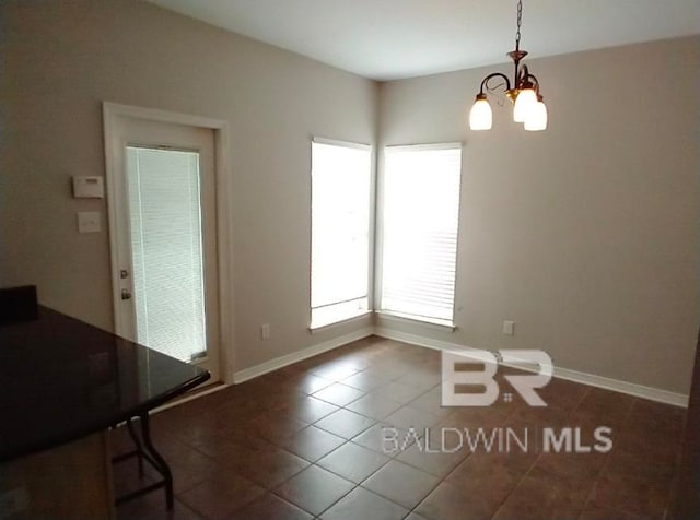 unfurnished dining area with an inviting chandelier and tile patterned flooring