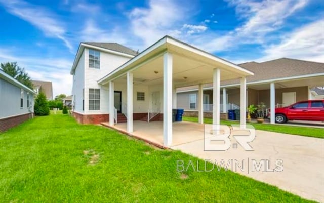 rear view of house with a carport and a yard