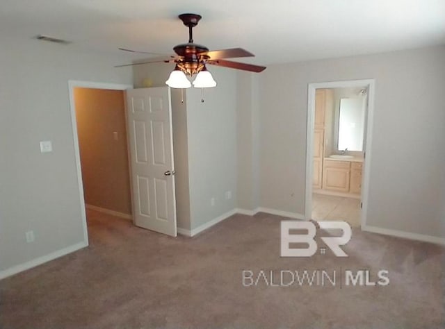 unfurnished room featuring ceiling fan, sink, and light colored carpet